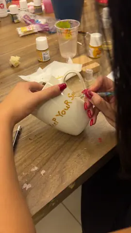 Writing a name in gold on a white mug