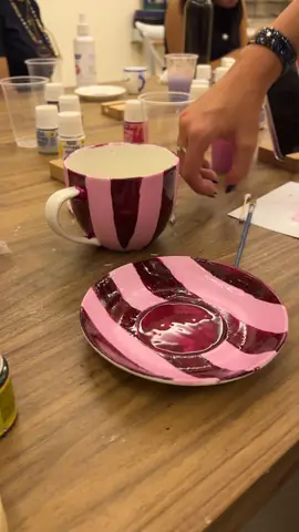 Pink striped mug and matching plate painted in a ceramic workshop