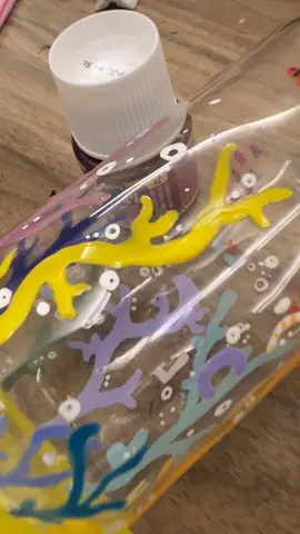 Close-up of a glass jar painted with corals in a glass painting workshop