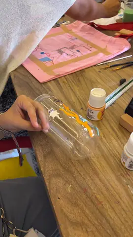 Painting orange details on a glass with a fine brush