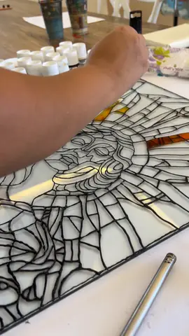 Outlining a vitrail design with black liner before painting