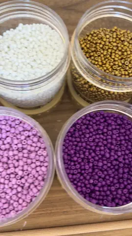 Jars of coloured seed beads for bead tapestry