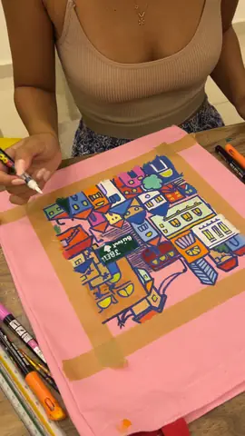 Adding colour to a city-houses design on a pink tote bag